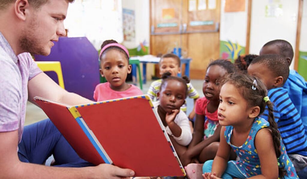 parent volunteer reading aloud to students