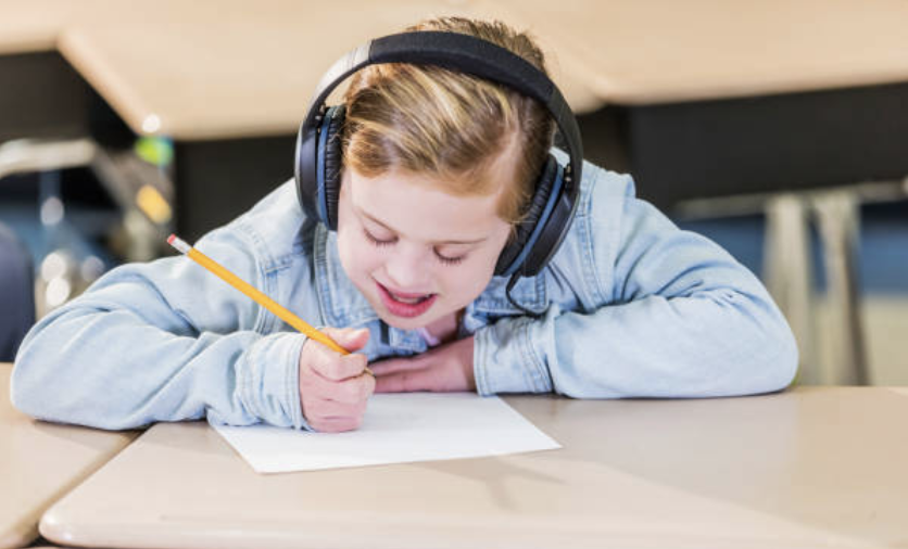 girl wearing headphones in a noisy classroom